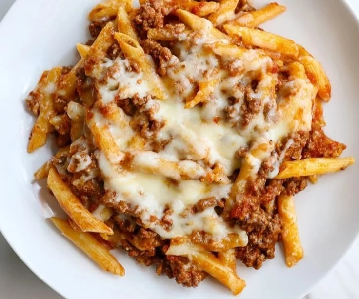 Cheesy beef penne bake topped with melted cheese and herbs