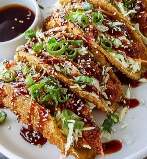 Crispy chicken wonton tacos topped with fresh ingredients.