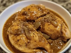 Crockpot Chicken with Onion Gravy served on a plate with fresh vegetables