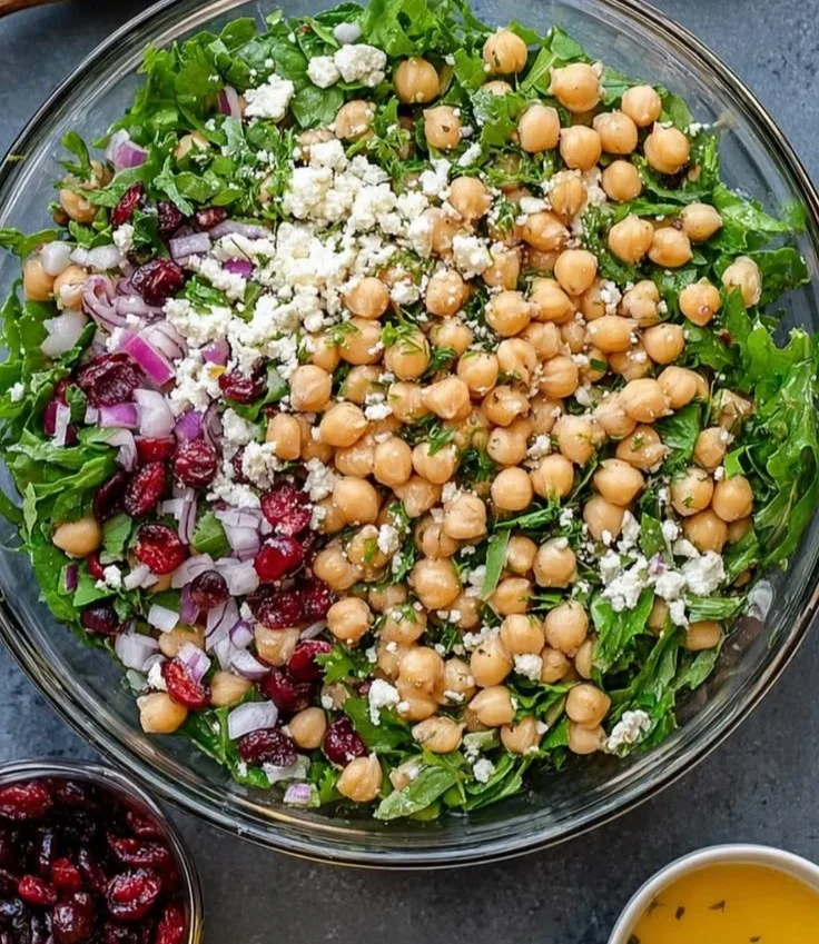 Feta and Cranberry Chickpea Salad in a bowl with fresh greens and toppings