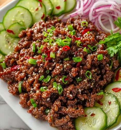 Delicious Korean ground beef served with a fresh cucumber salad on a plate.