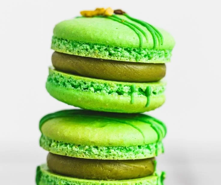 Pistachio macarons filled with creamy pistachio ganache on a decorative plate