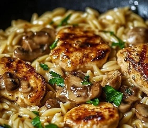 Savory Marsala Chicken served with creamy orzo on a plate