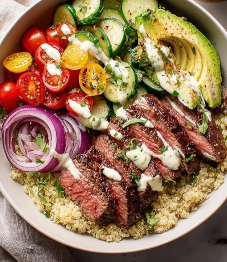 Delicious Steak Quinoa Bowl topped with fresh vegetables and herbs