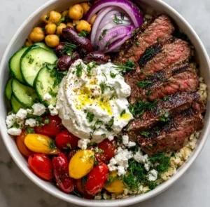 Mediterranean Steak Bowl garnished with fresh herbs and vegetables
