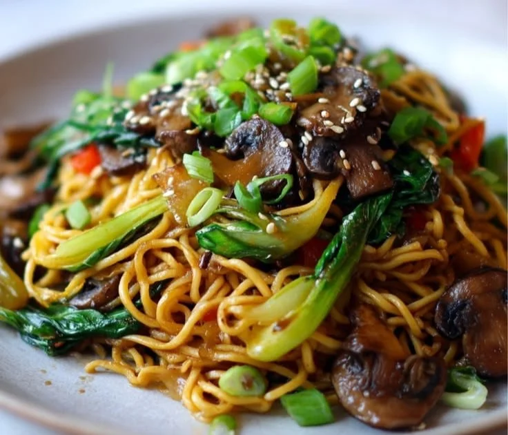 Delicious bowl of Garlic and Mushroom Chow Mein noodles garnished with herbs.