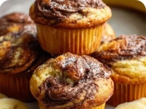 Nutella banana muffins with chocolate swirls and banana slices on a plate