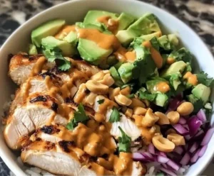 Thai Peanut Chicken Buddha Bowl with fresh vegetables and peanut sauce