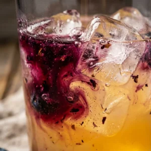 A refreshing glass of homemade blueberry lemonade garnished with fresh blueberries and lemon slices.